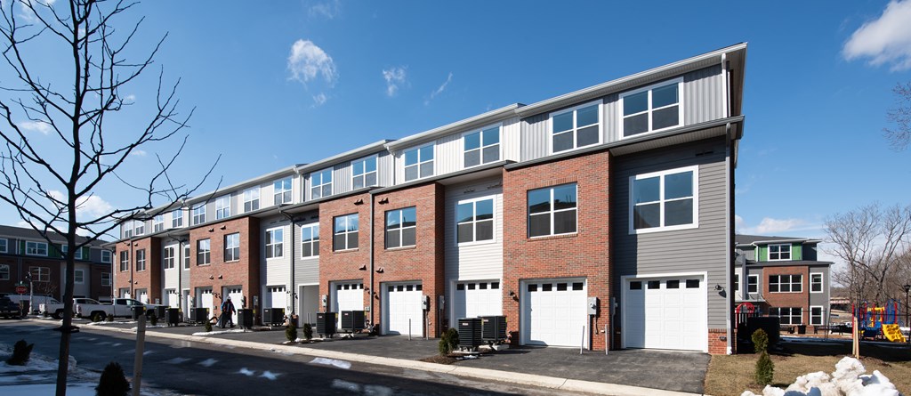 a three story brick apartment building with white doors and windows