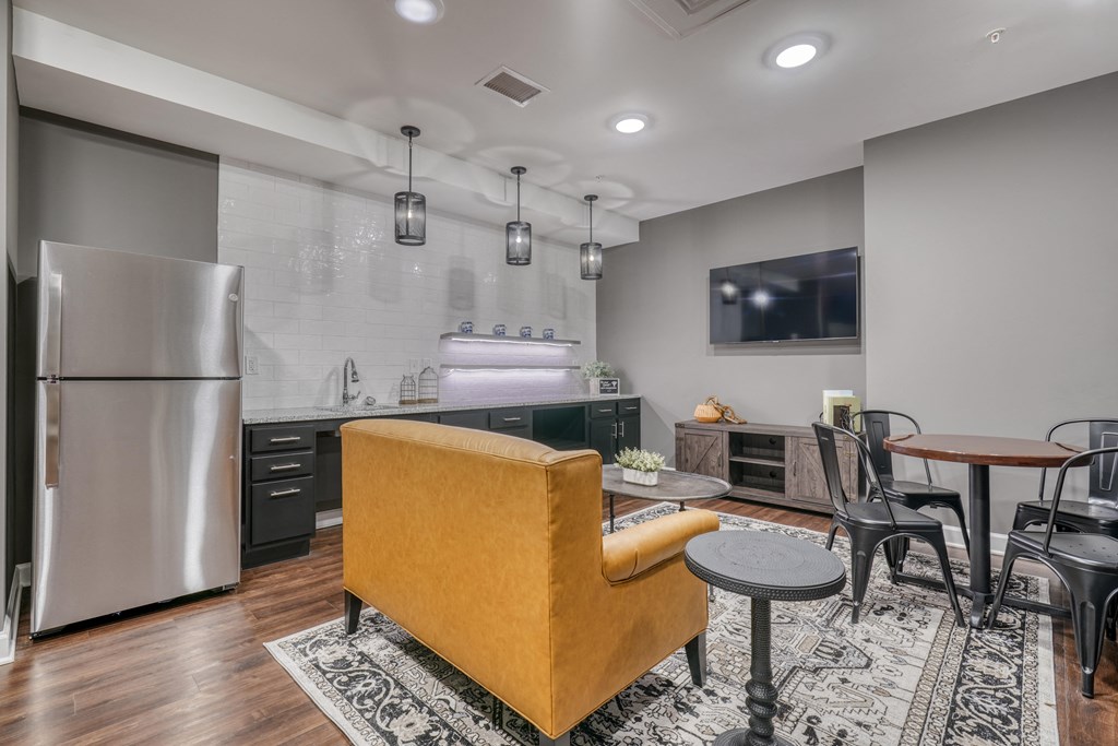 a kitchen and living room with a refrigerator and a table and chairs