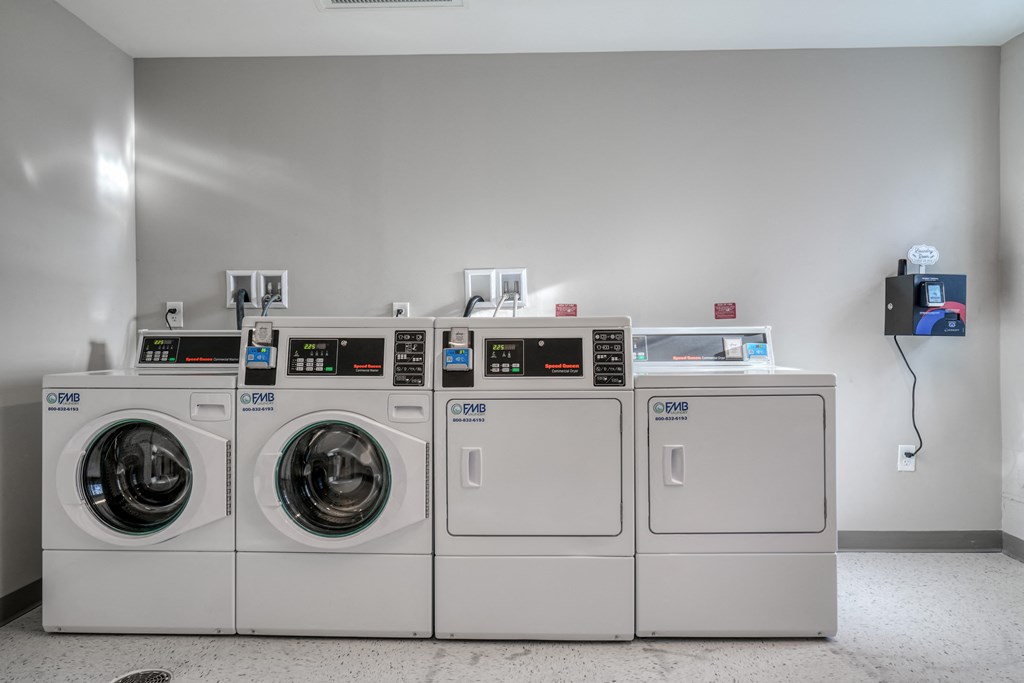 a row of washers and dryers in a laundry room