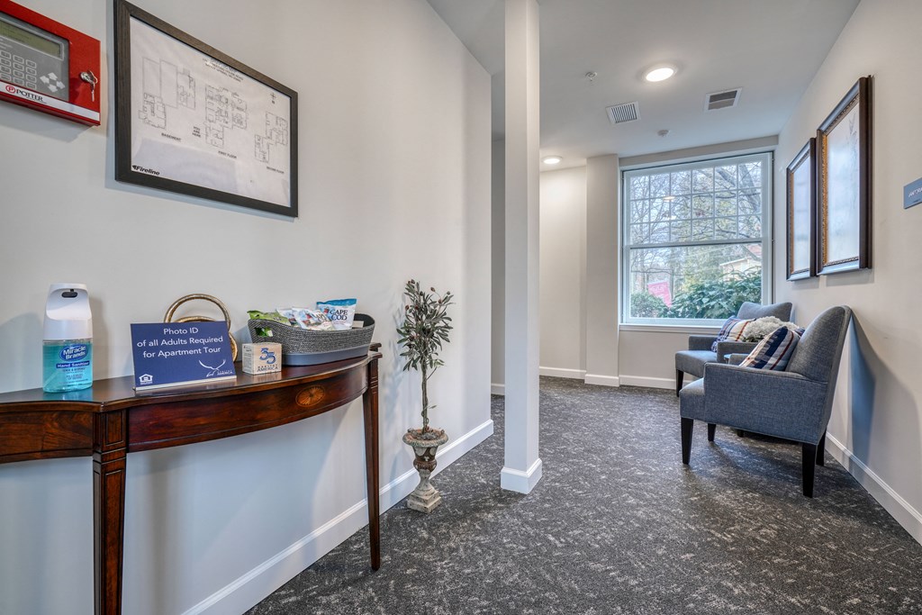 a living room with a desk and a chair and a window