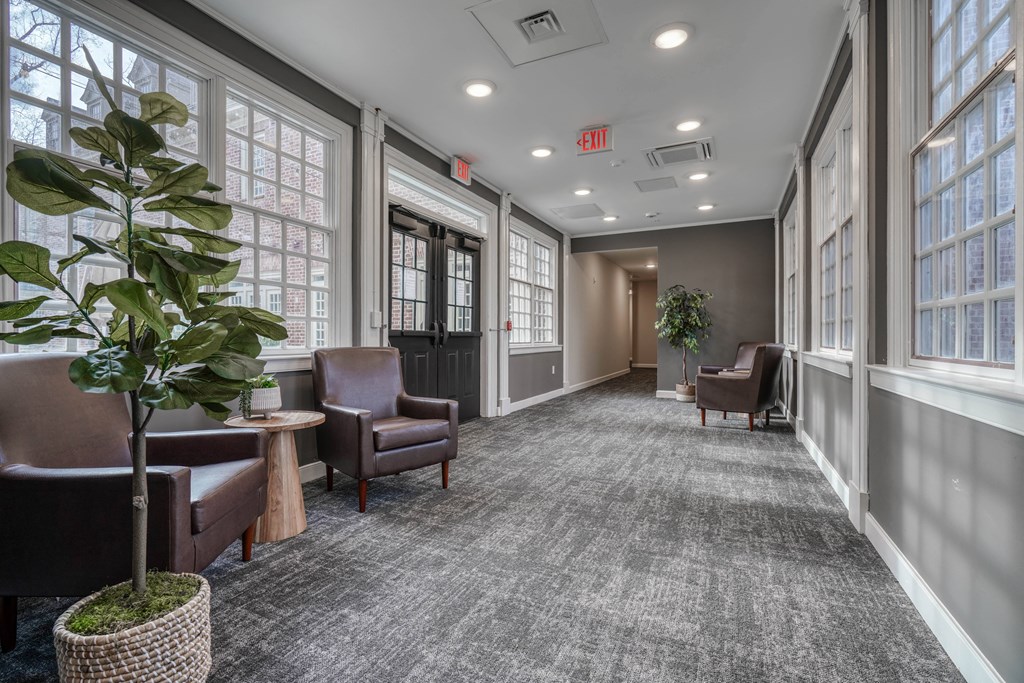 an empty hallway with chairs and a plant