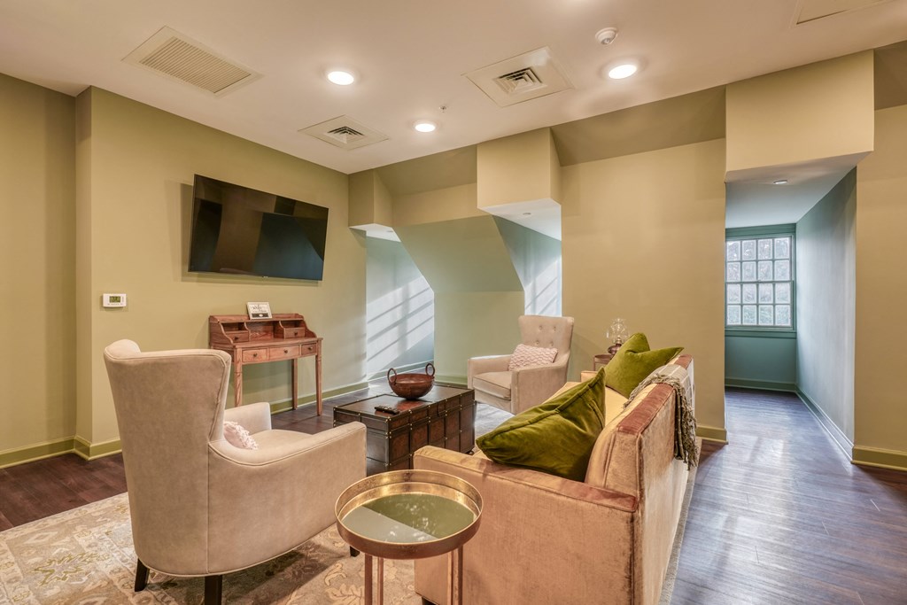 a living room with couches and chairs and a television