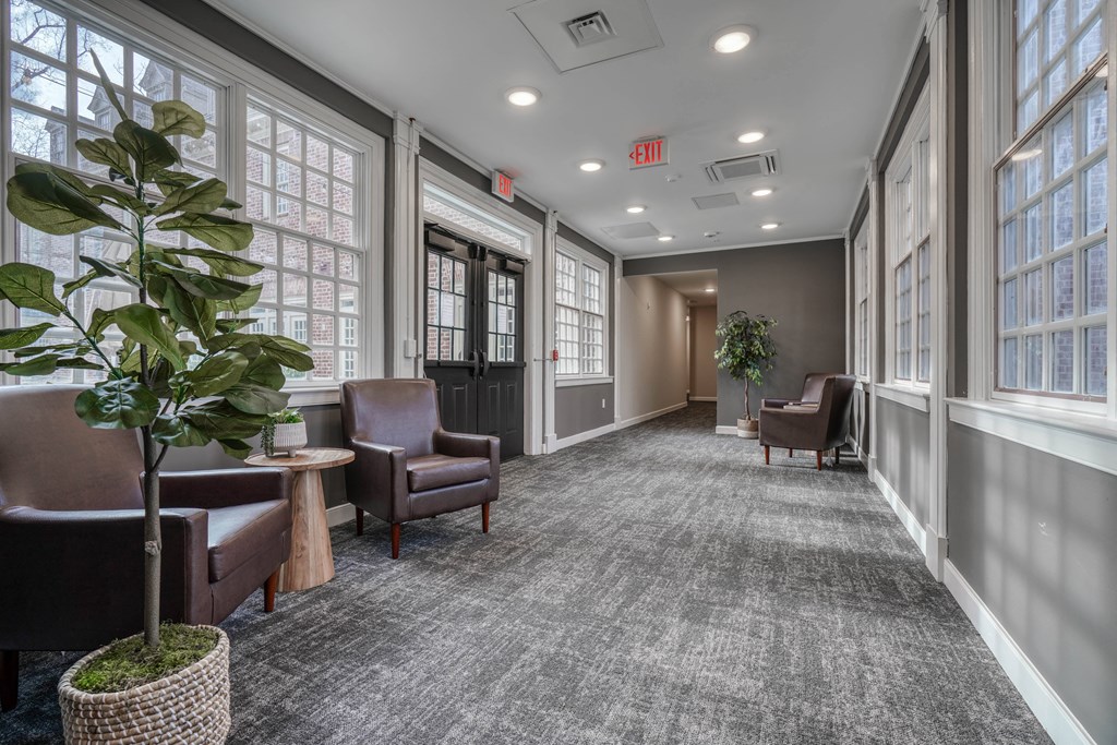 an empty hallway with chairs and a plant