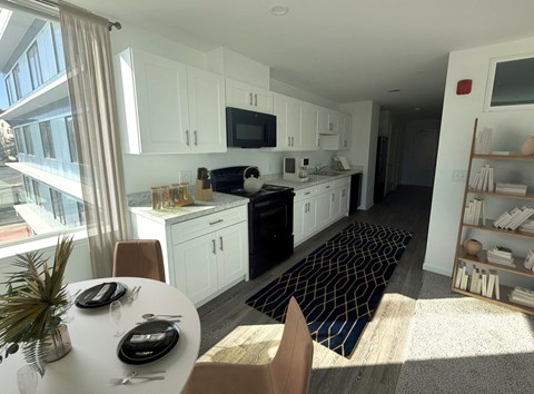 A kitchen with white cabinets and a black stove top oven.