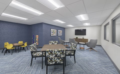 A conference room with a long table surrounded by chairs.