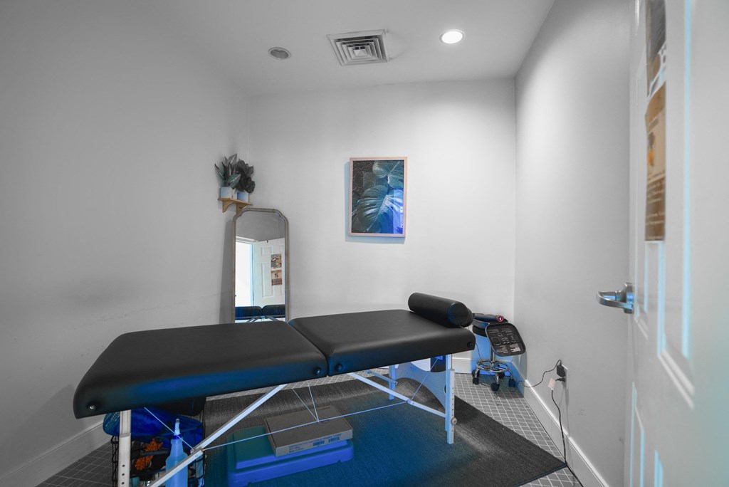 a treatment room with two massage tables and a mirror