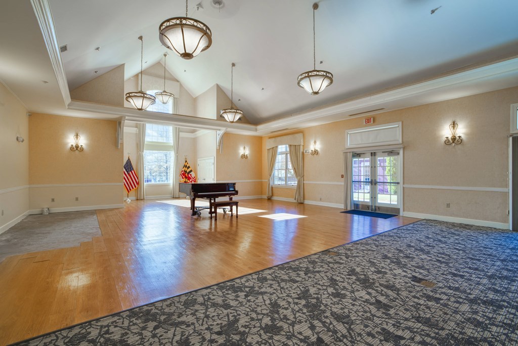 an empty living room with a grand piano and a rug