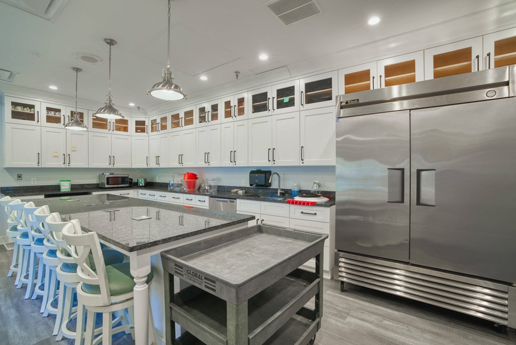 the kitchen has a large island and stainless steel appliances