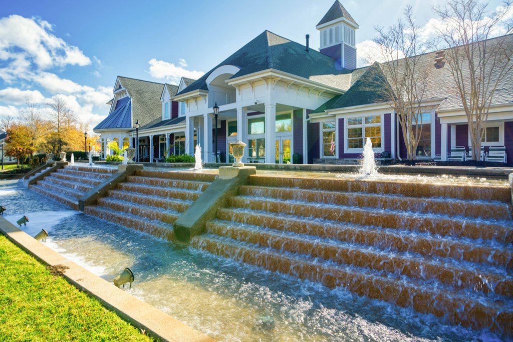 a large house with a fountain in front of it