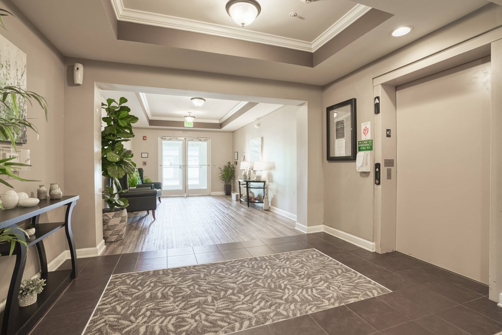 a large hallway with a rug and a door to a lobby