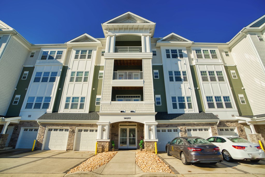 a large apartment building with cars parked in front of it