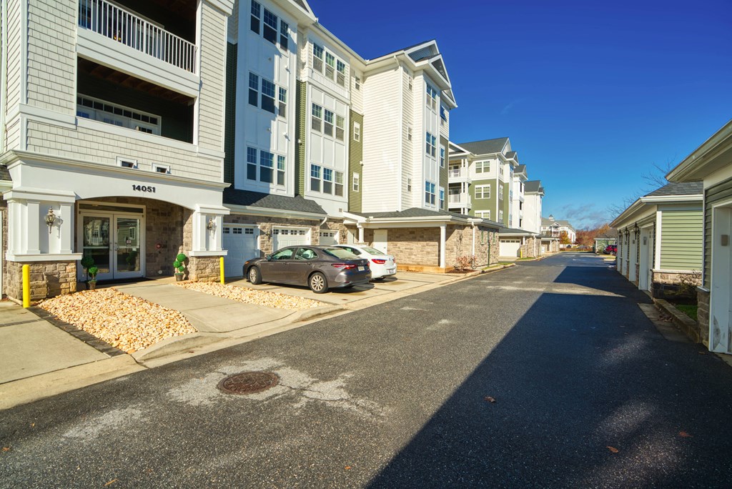 a street with white houses on either side and a car parked in front