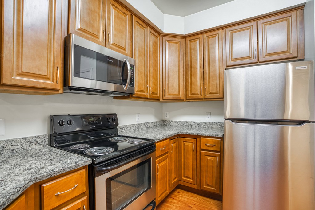 an empty kitchen with wood cabinets and stainless steel appliances