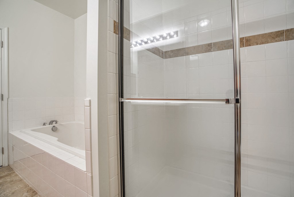 a white bathroom with a shower and a tub