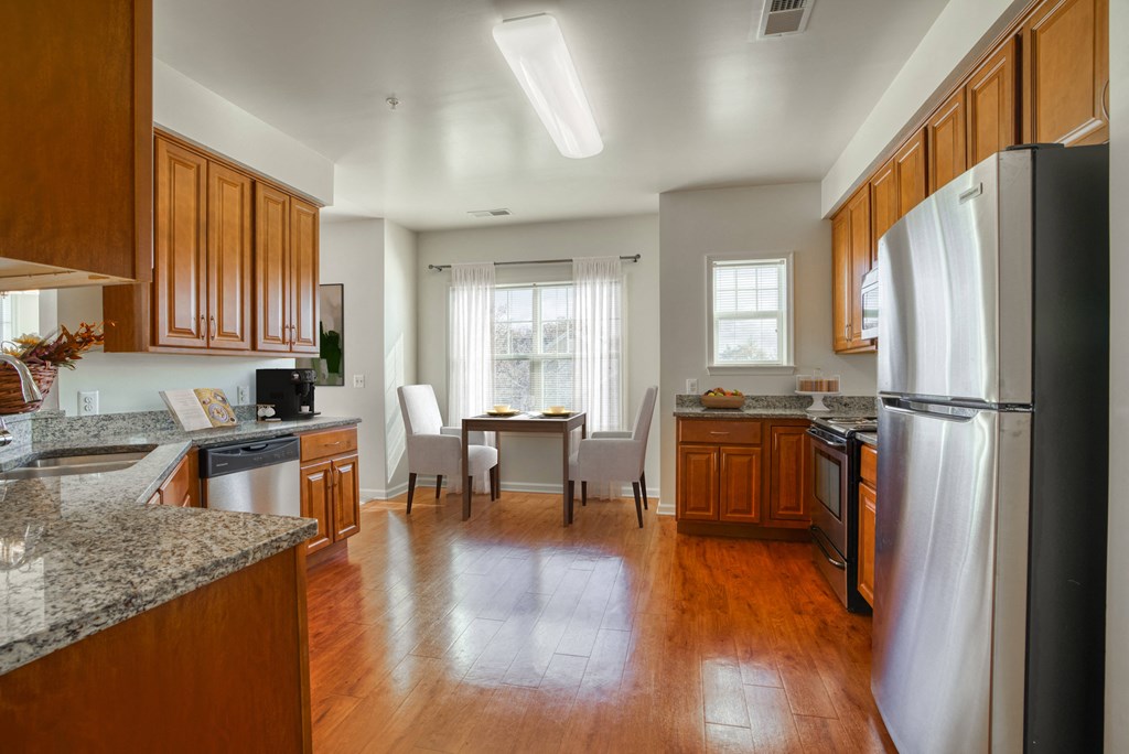 a kitchen and dining room with wood floors and stainless steel appliances