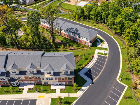A curved road in front of a building surrounded by trees.