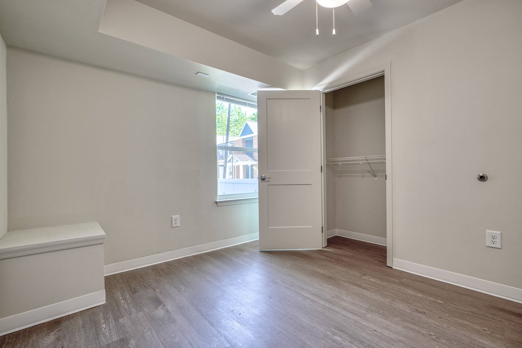 an empty bedroom with a closet and a window