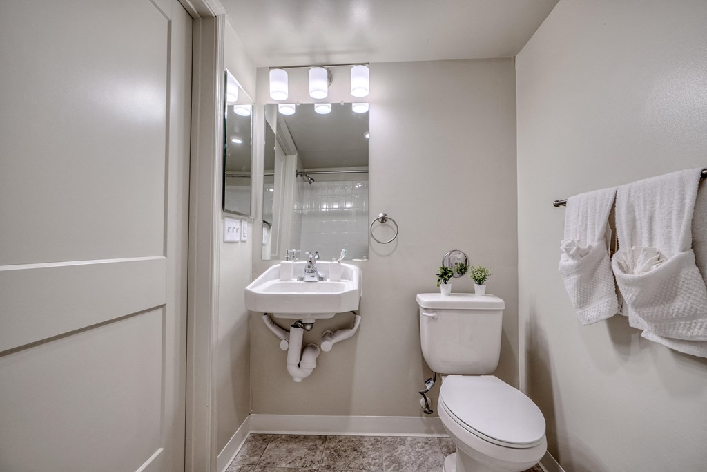 a small bathroom with a toilet and a sink and a mirror