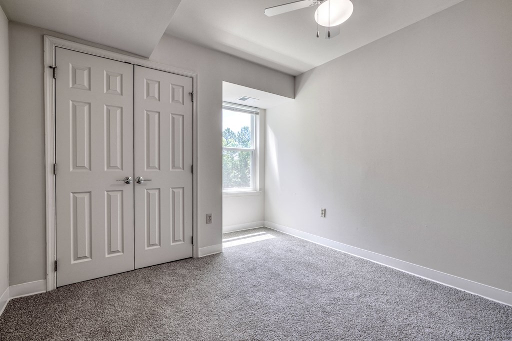 an empty room with a closet and a window
