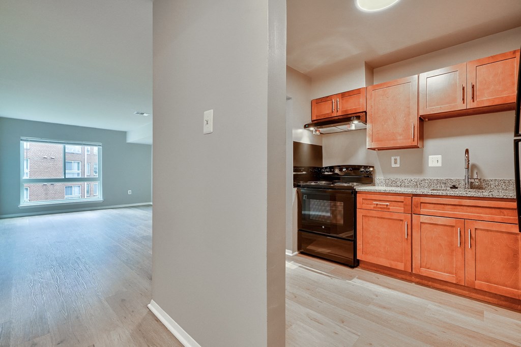 a kitchen and living room with wood cabinets and black appliances