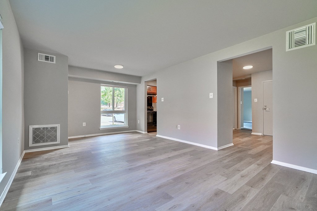 Spacious one bedroom living room with luxury vinyl plank flooring and a large window