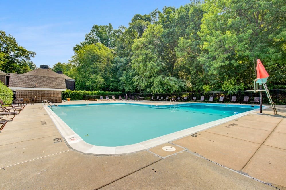 a swimming pool with trees in the background