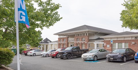 A parking lot with cars and a building in the background.