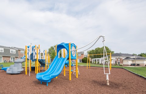 A playground with a blue slide and yellow poles.