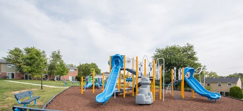 A playground with a blue and yellow slide.