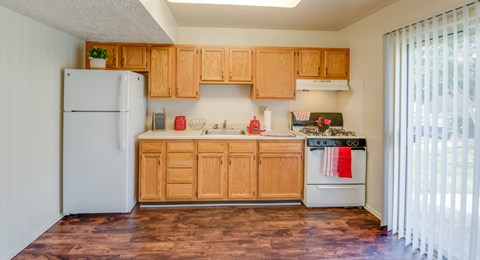A kitchen with wooden cabinets and a white refrigerator.