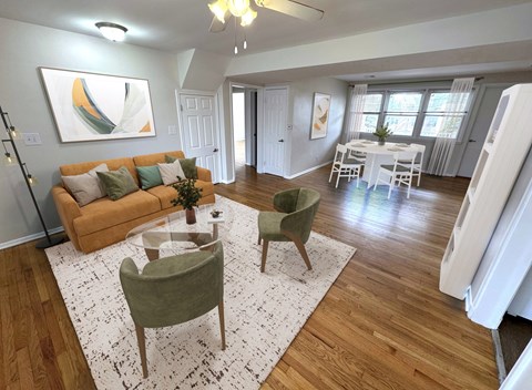A living room with a couch, chairs, and a dining table.