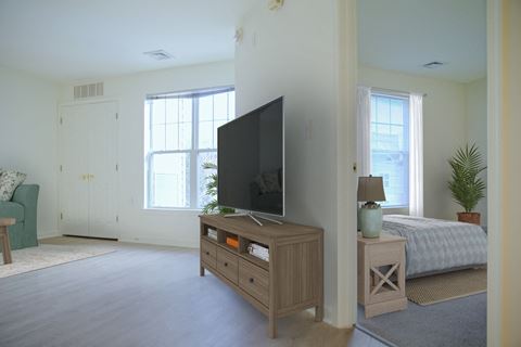 a living room with a tv and a bed