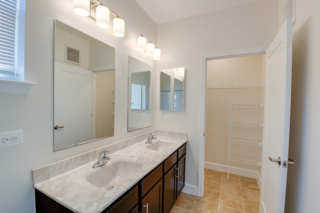 a bathroom with two sinks and three mirrors