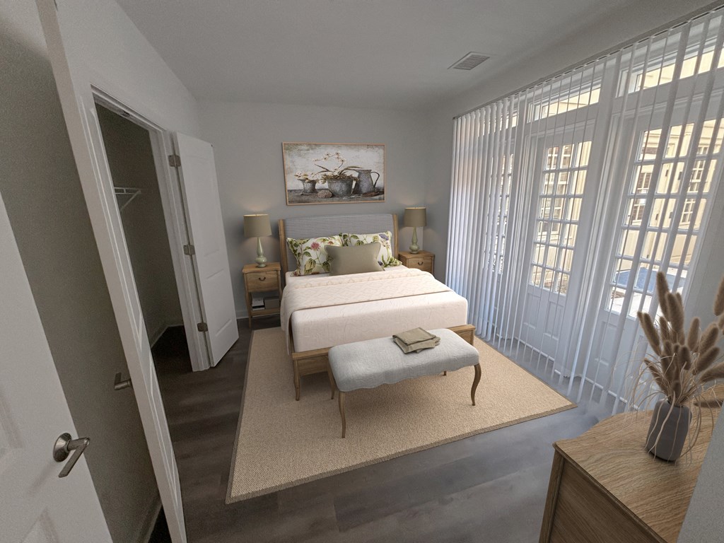 a bedroom with a bed and a ottoman in a room with large windows