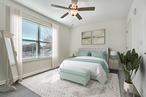 A bedroom with a bed, a bench, and a ceiling fan.