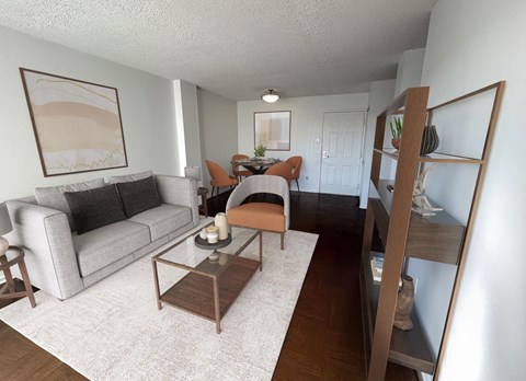 A living room with a grey couch, a brown coffee table, and a painting on the wall.