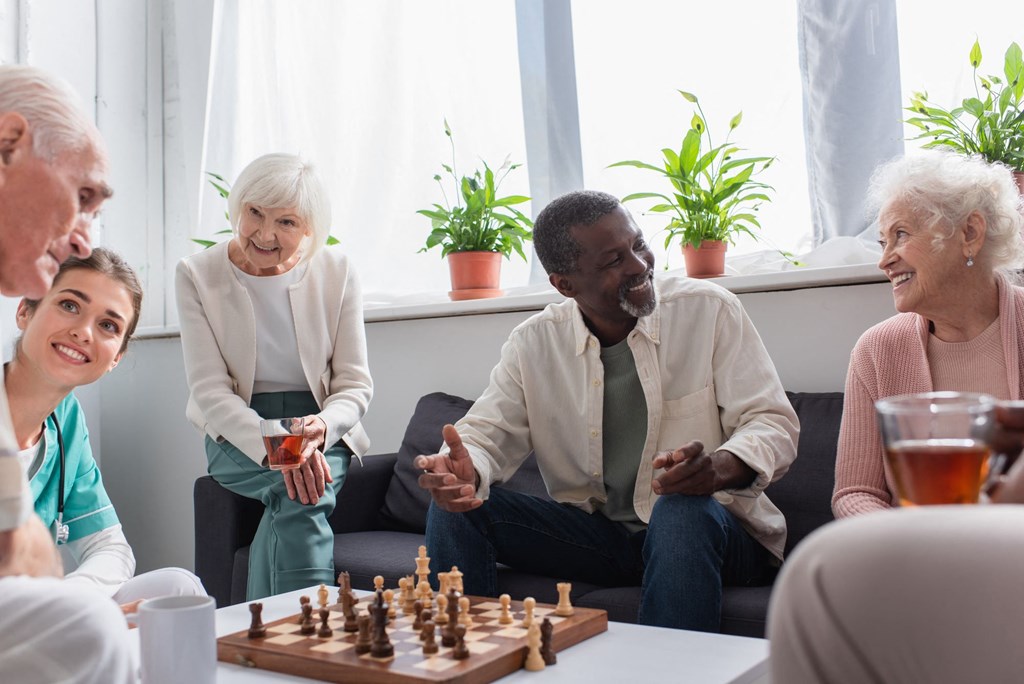 a group of people sitting around a table playing chess