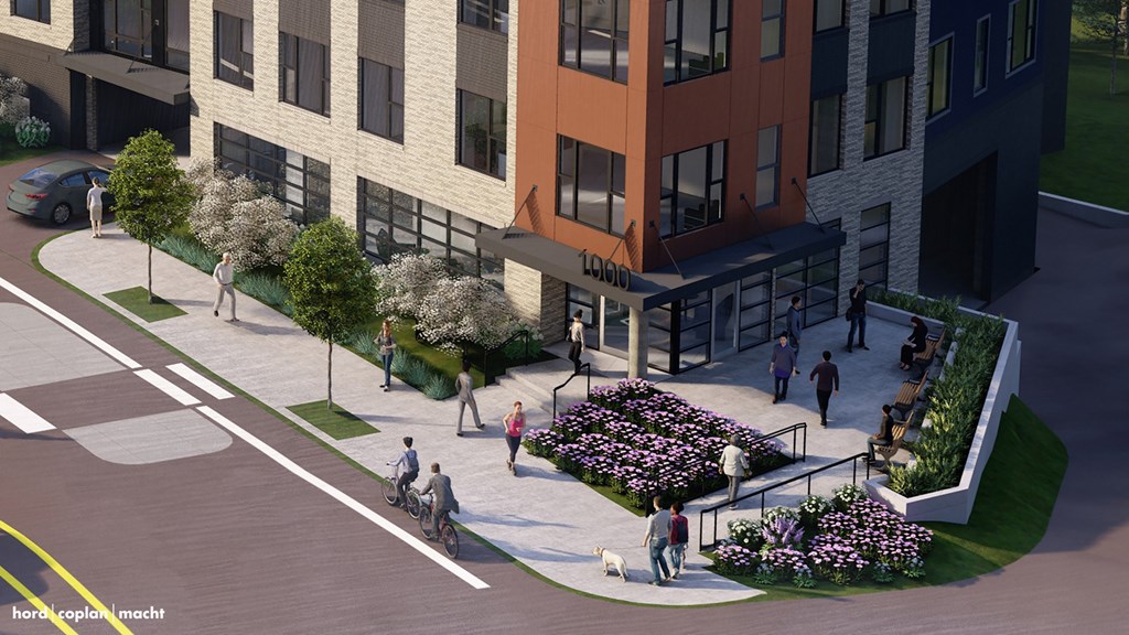 A street view of a building with a flower bed in front of it.