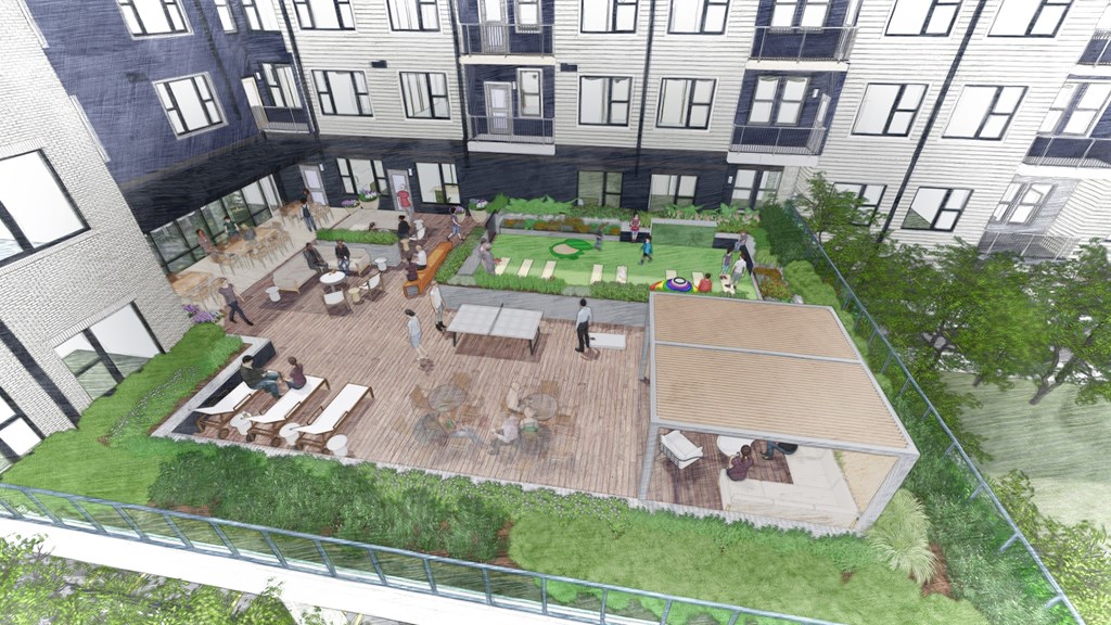 A rooftop garden with a seating area and a green lawn.