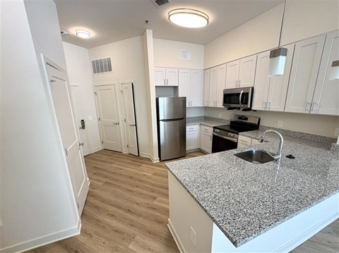 A kitchen with a granite countertop and stainless steel appliances.
