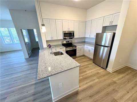 A kitchen with a granite countertop and stainless steel appliances.