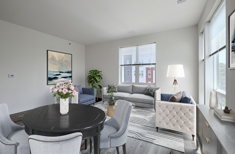 A modern living room with a black table and grey chairs.