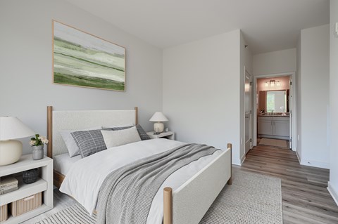 A bedroom with a large bed and a painting on the wall.