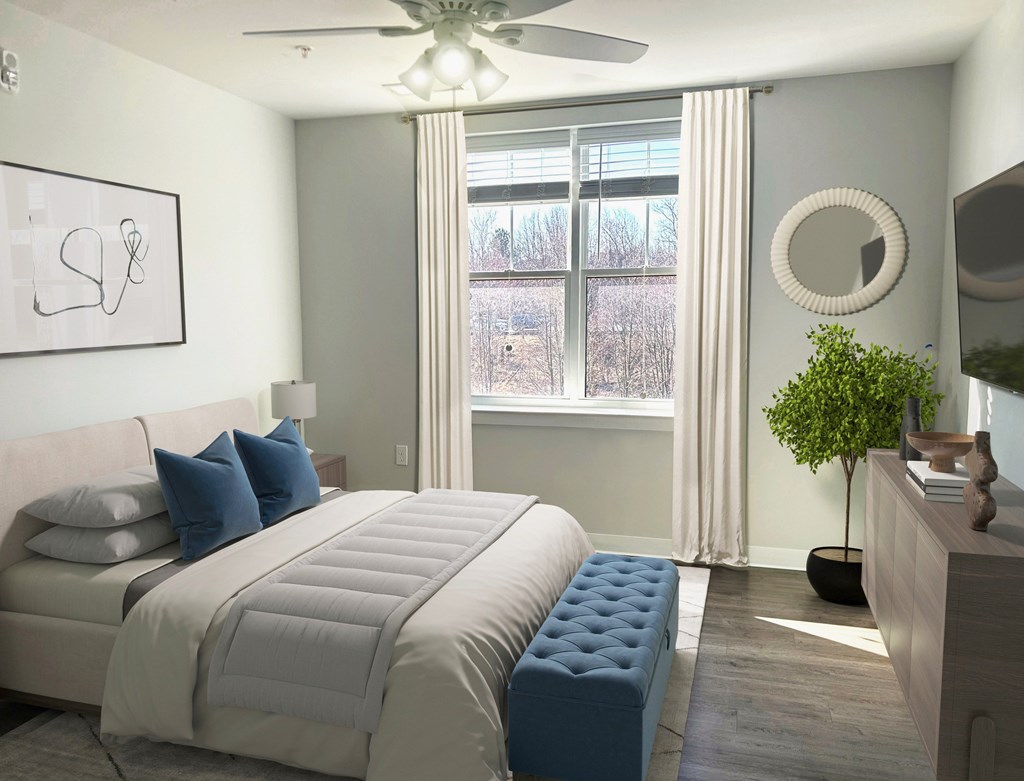A bedroom with a large bed and a ceiling fan.