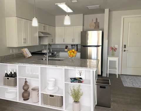 A kitchen with white cabinets and a granite countertop.