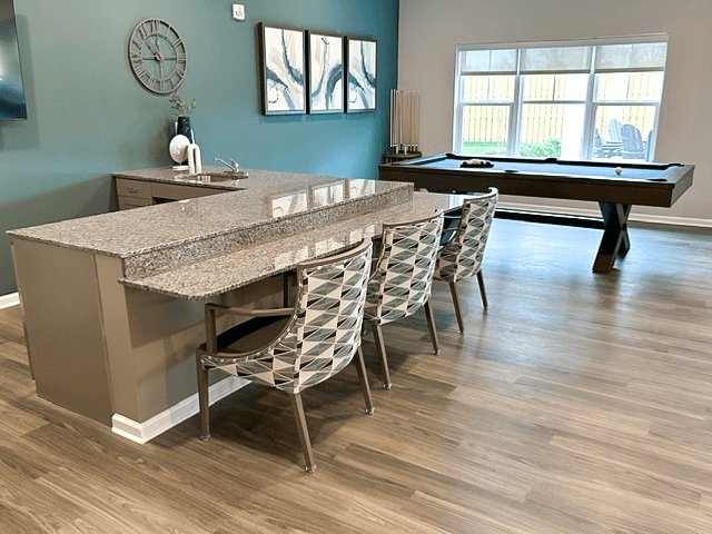 a kitchen with a bar and chairs and a pool table