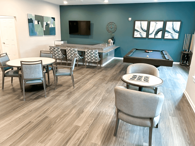 a common room with a pool table and tables