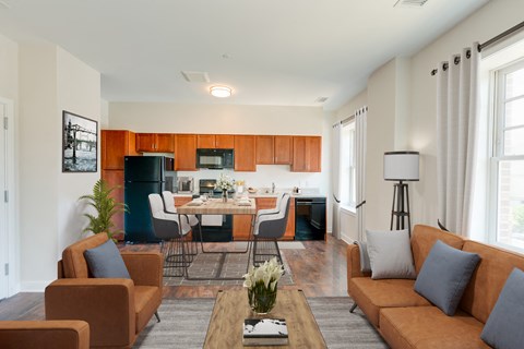 a living room with couches and a table in front of a kitchen