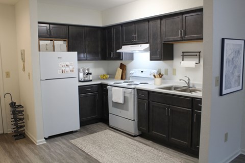 a kitchen with white appliances and black cabinets and a white refrigerator