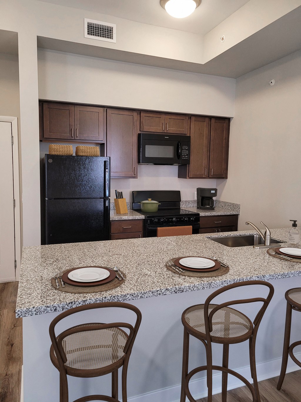a kitchen with a granite counter top and black appliances